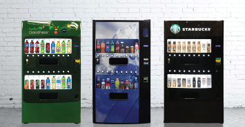 three vending machines are lined up against a white brick wall