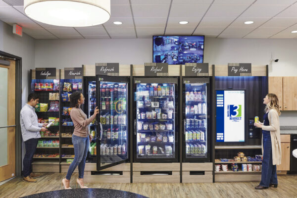 a couple of people standing in front of a vending machine